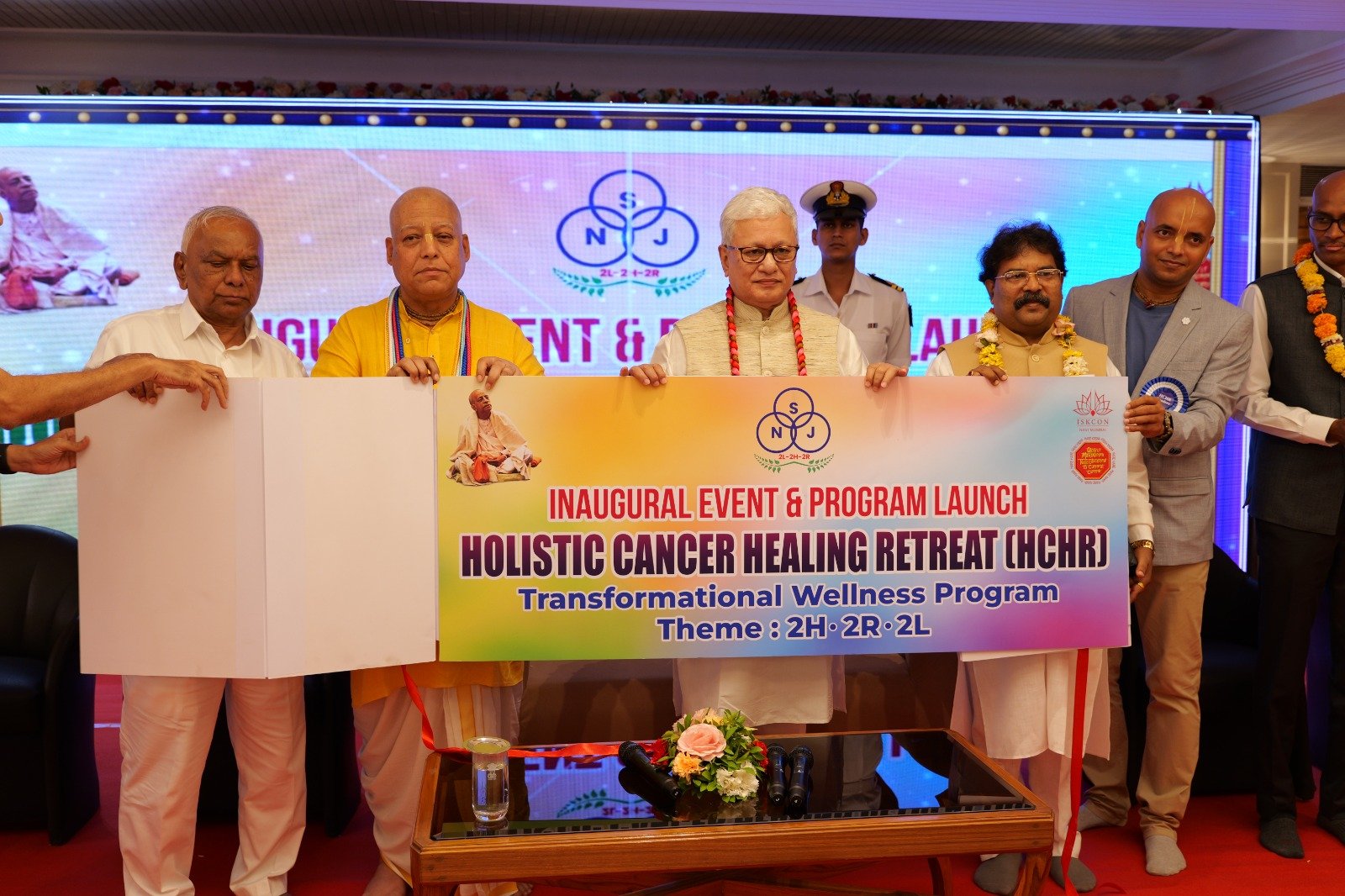 The Holistic Cancer Healing Retreat inauguration banner being unveiled on stage